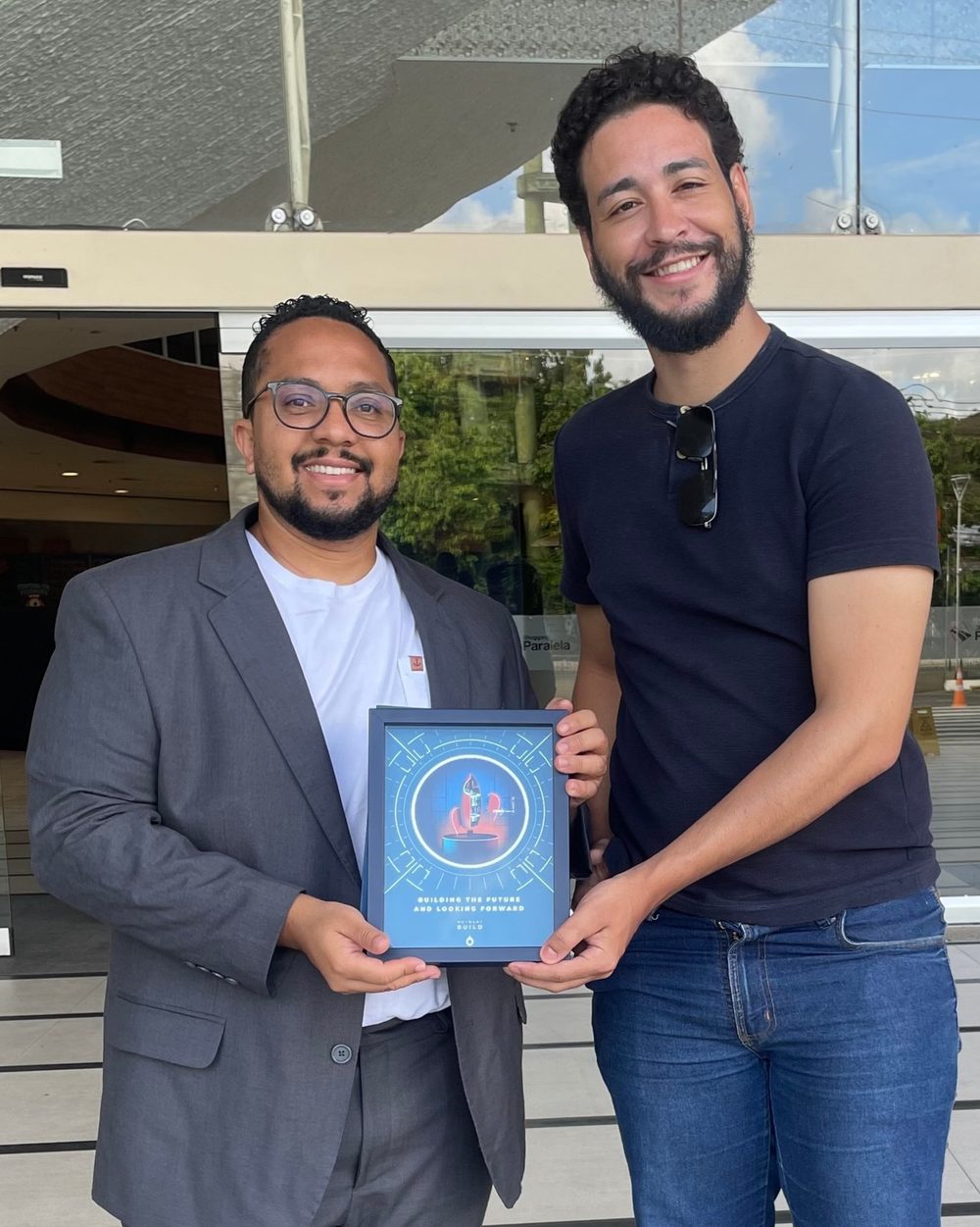 Diego Nascimento e Lucas Braz segurando a placa de reconhecimento da Hotmart